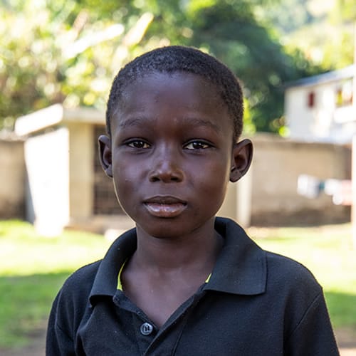 Orphan & Vulnerable Children Ministries (OVCM) depatment at Hope International Missions Child in front of a building